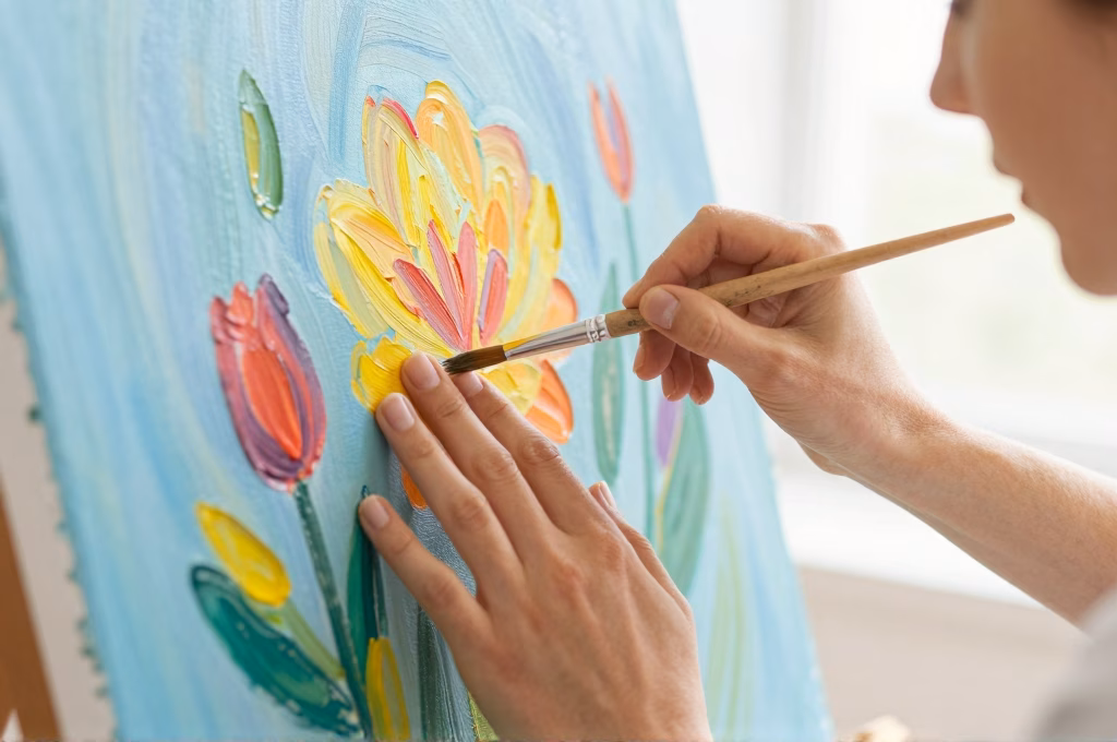 Mains d'une femme creant une peinture coloree en art-thérapie, palette de couleurs vives